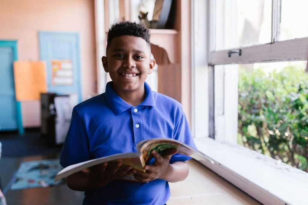 kid with book in hand smiling